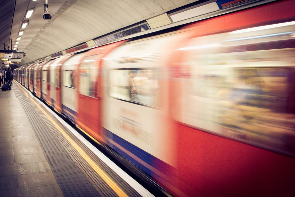 A blurred photo of a train passing through a subway station at speed.