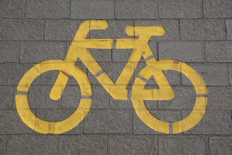 A painted bicycle sign on a grey paved road
