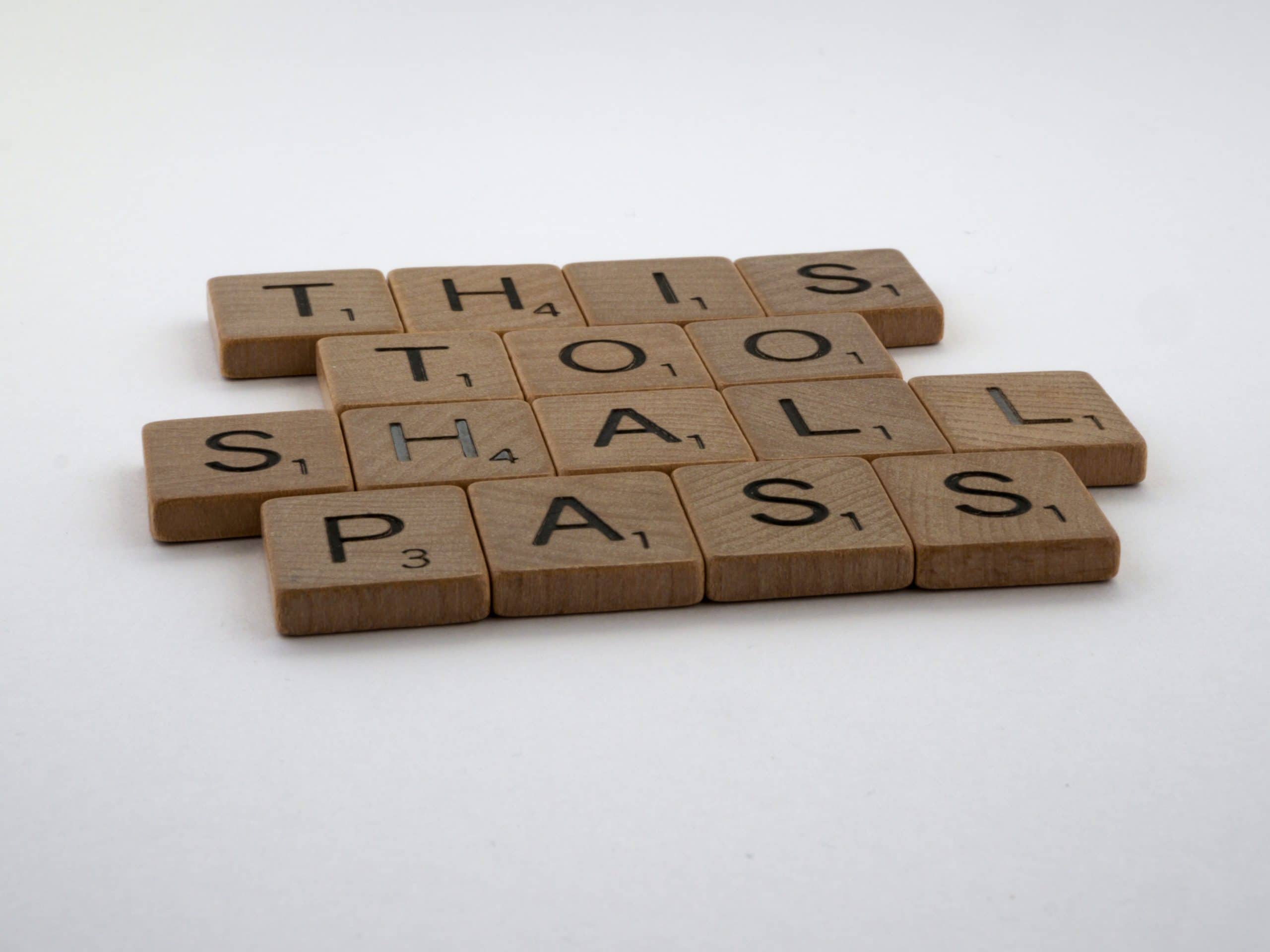 Photo of wooden letter tiles spelling out the advice "this too shall pass"