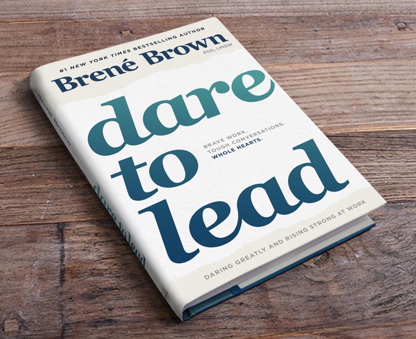 Book lying on wooden surface: Dare to Lead by Brene Brown