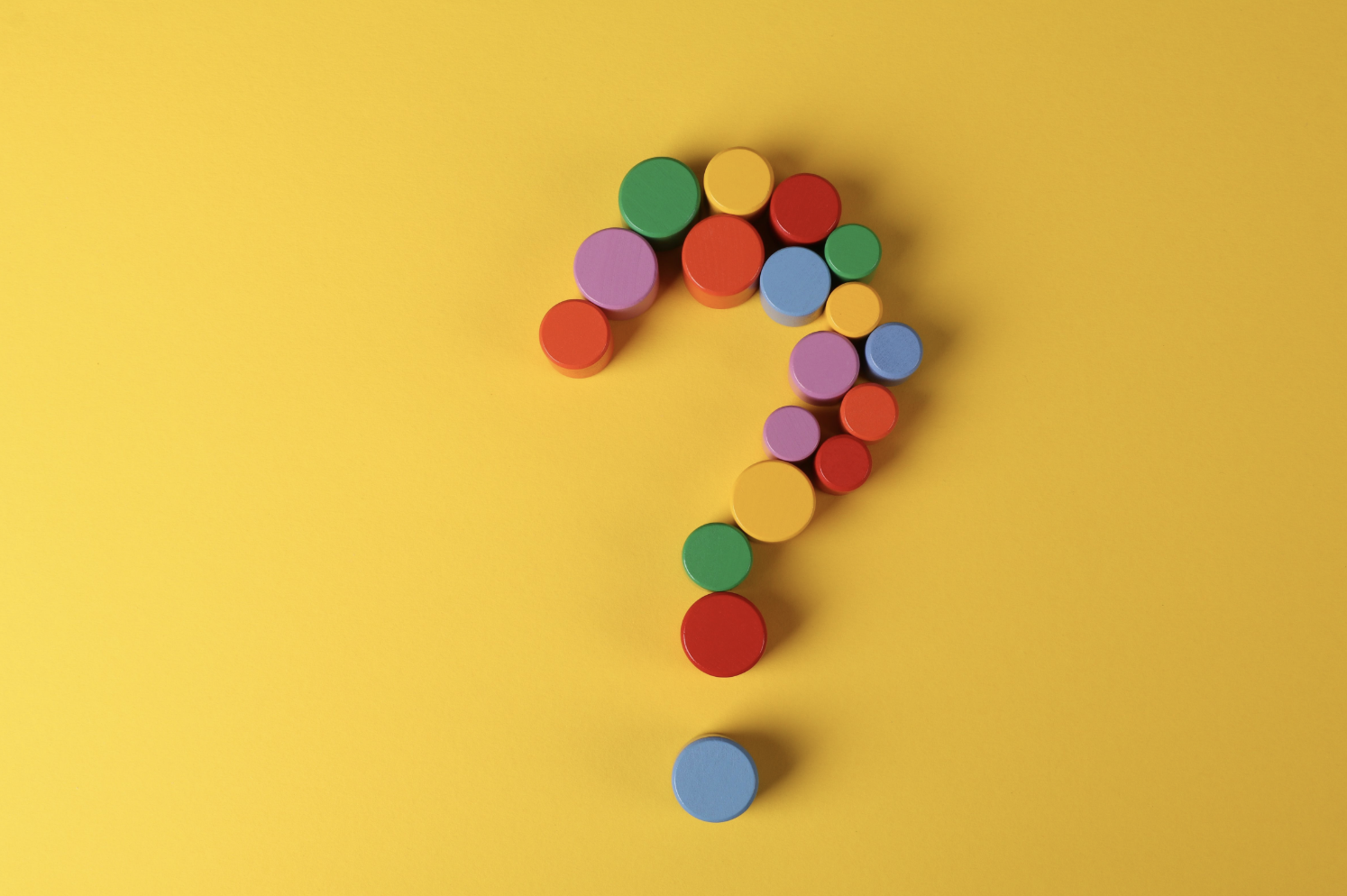 A multicoloured question mark on yellow background.