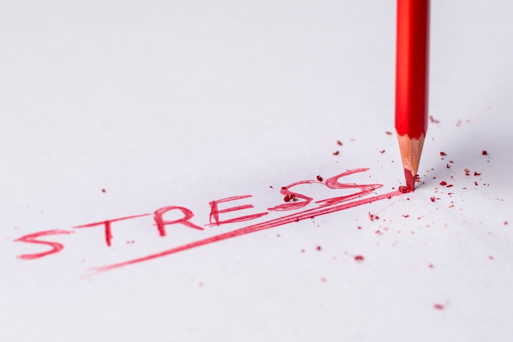 Photo of a red pencil that has written the word "stress" and underlined it multiple times