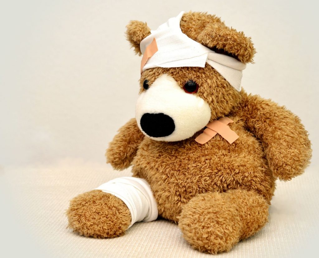 A soft-toy teddy bear with bandages and sticky plasters
