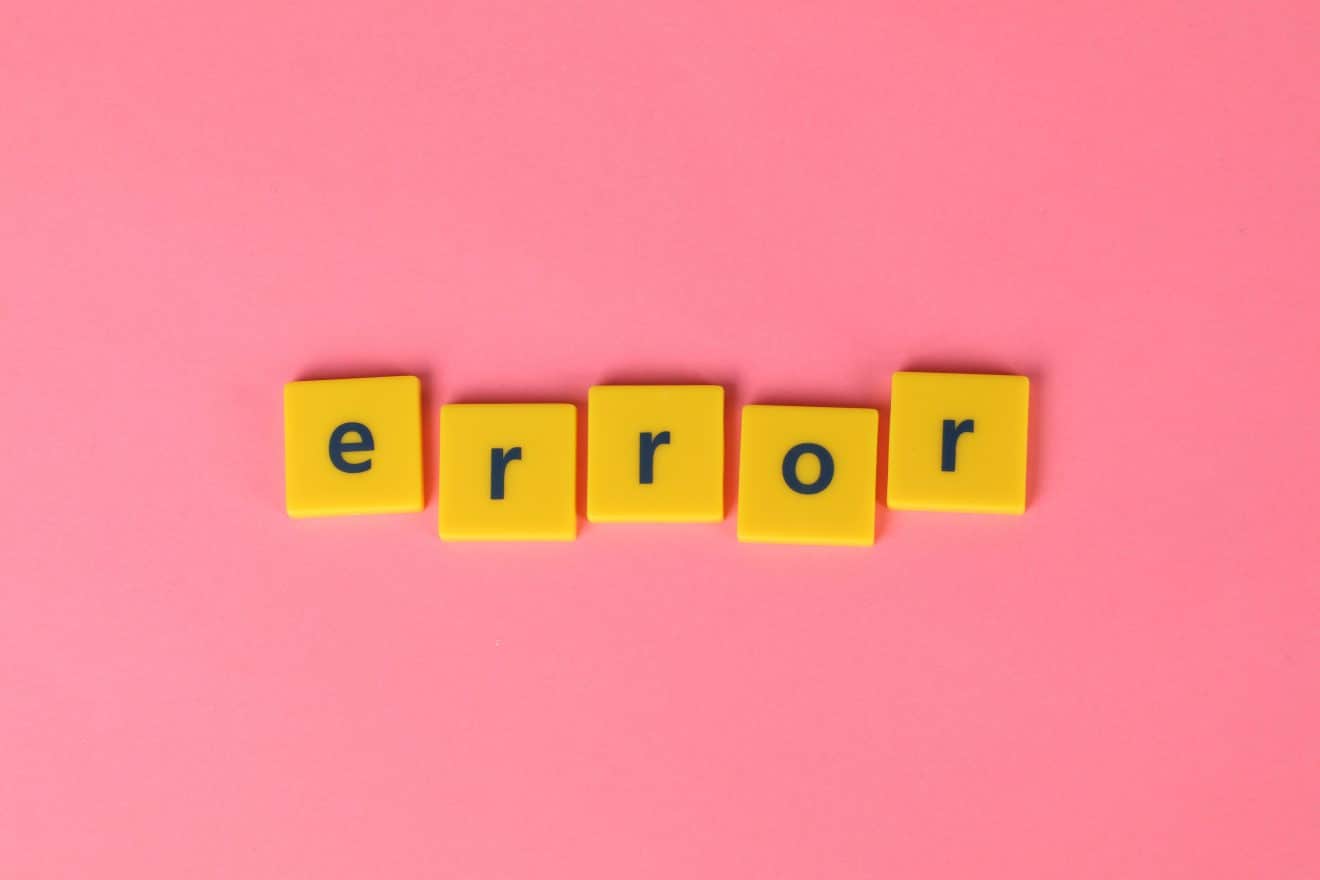 Photo of yellow letter tiles on a pink background, spelling out "error"