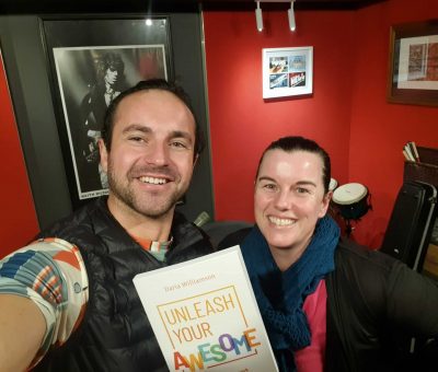 A selfie photo of a man and a woman smiling at the camera, during the recording of the Unleash Your Awesome audiobook