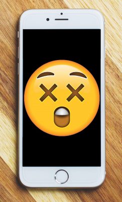 A mobile phone with a shocked/surprised emoji on the screen